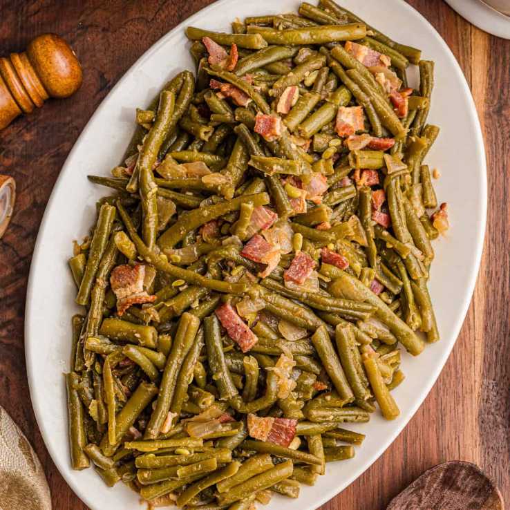 Oven-roasted green beans with bacon and parmesan cheese on a baking sheet